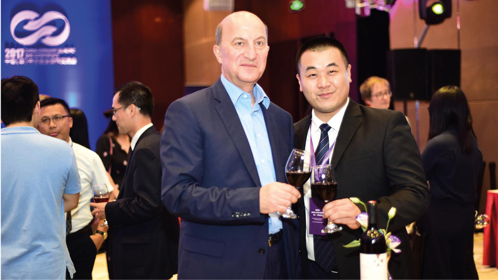 Michael Höferer und der chinesische Unternehmer Wu Kedong stoßen mit Deutschkreutzer Rotwein an.