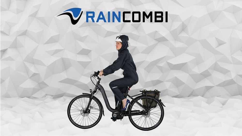 Frau am Fahrrad die den Raincombi Regenoverall trägt